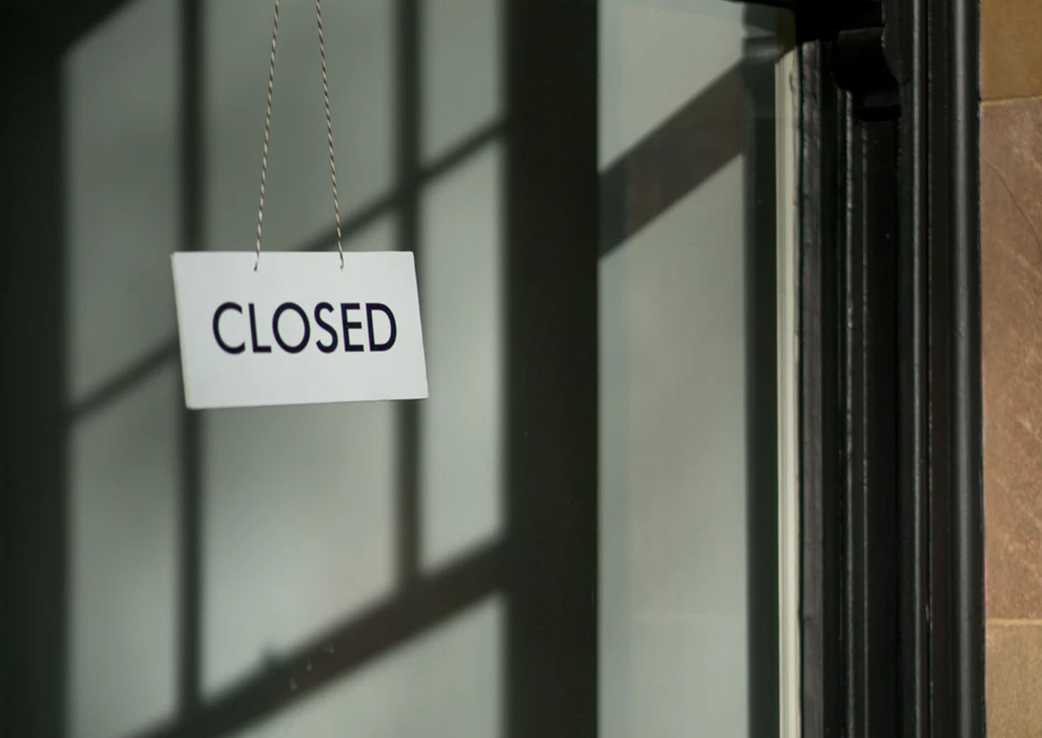 Image of a "closed" sign hanging in the door