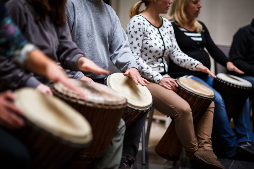 Image of a group of people drumming together