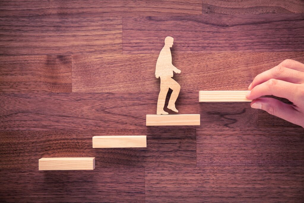 Wooden figure of a man climbing stairs