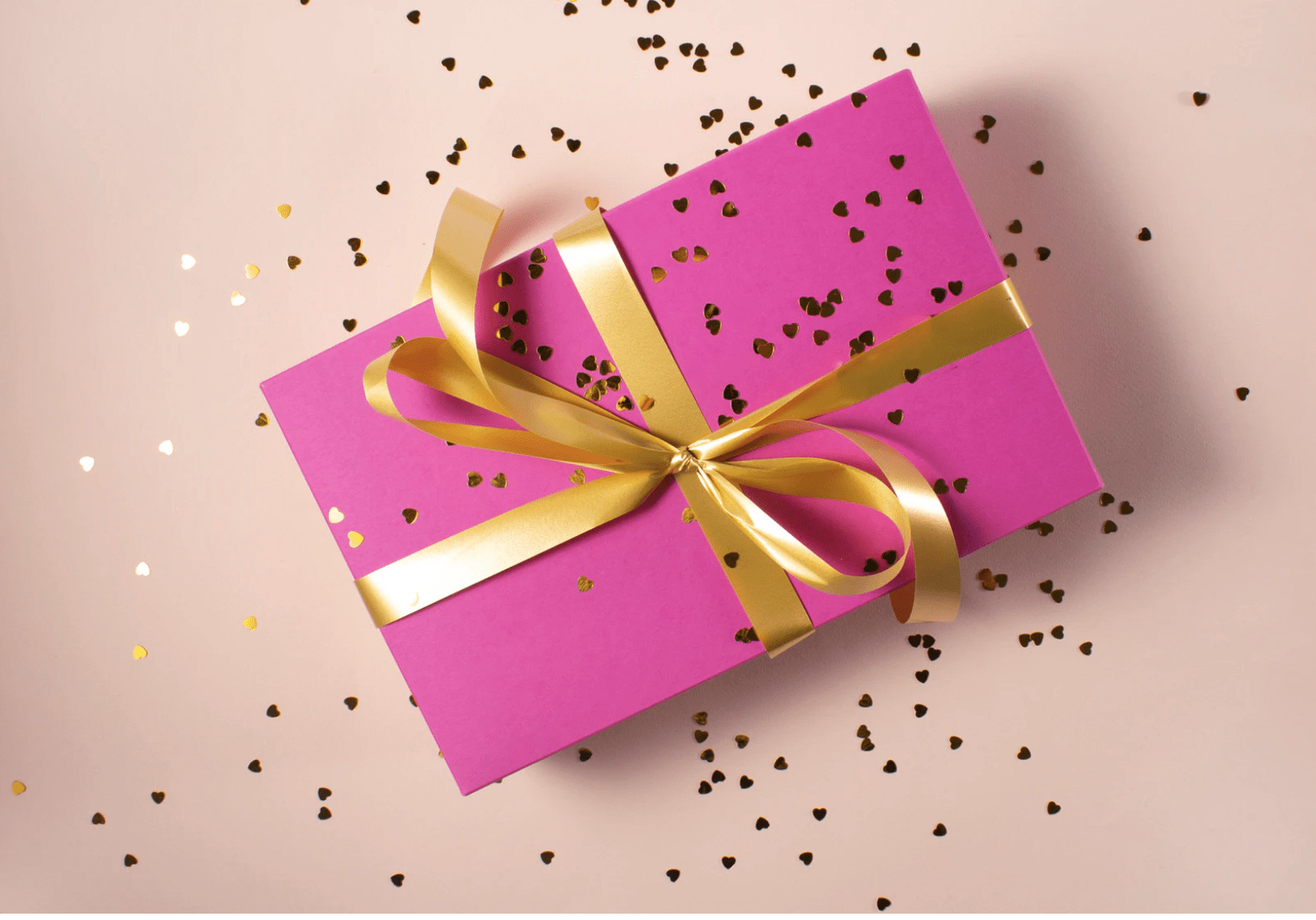 En innpakket gave i rosa papir og gulltråd