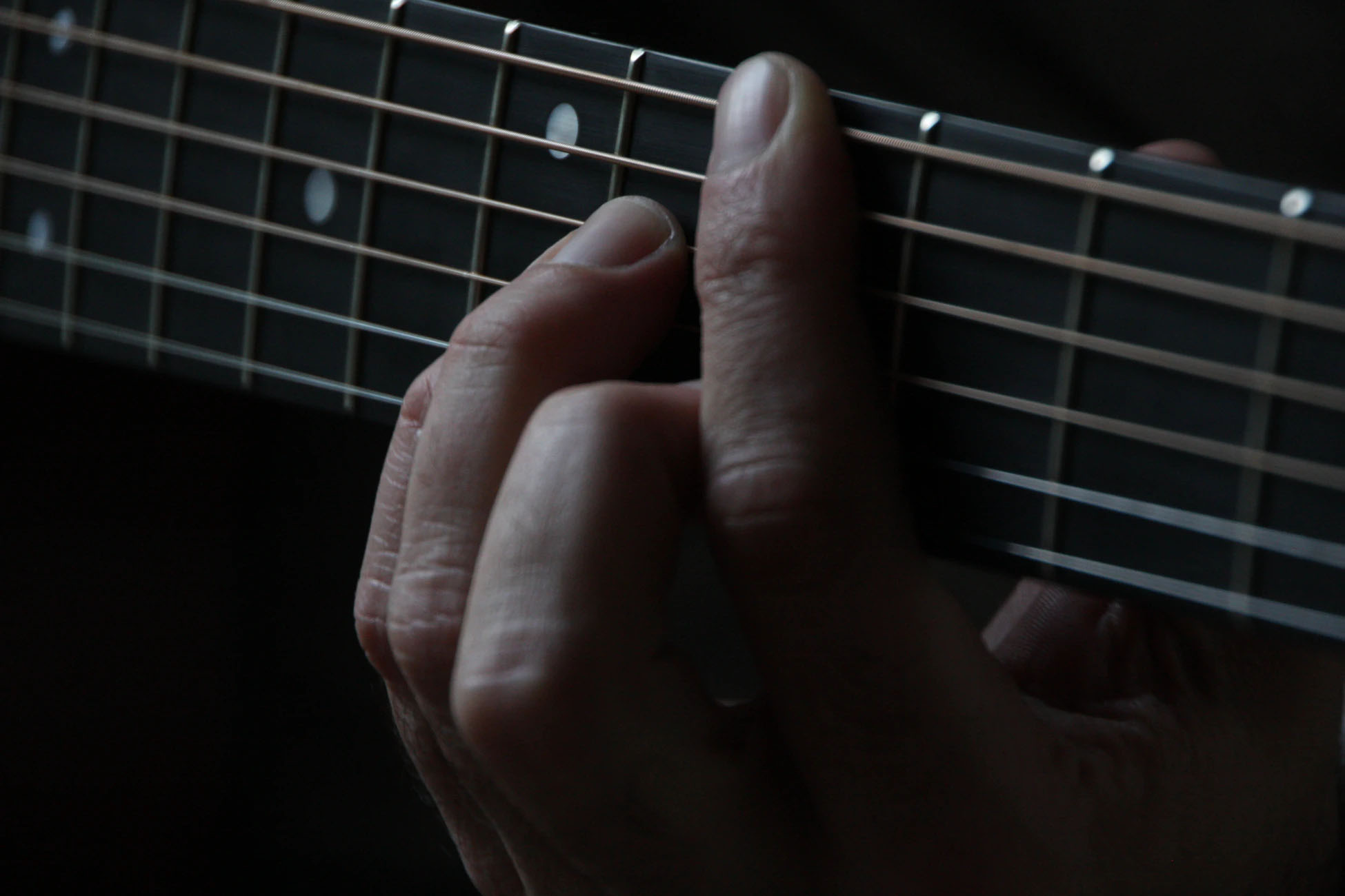 Image of fingers on guitar strings