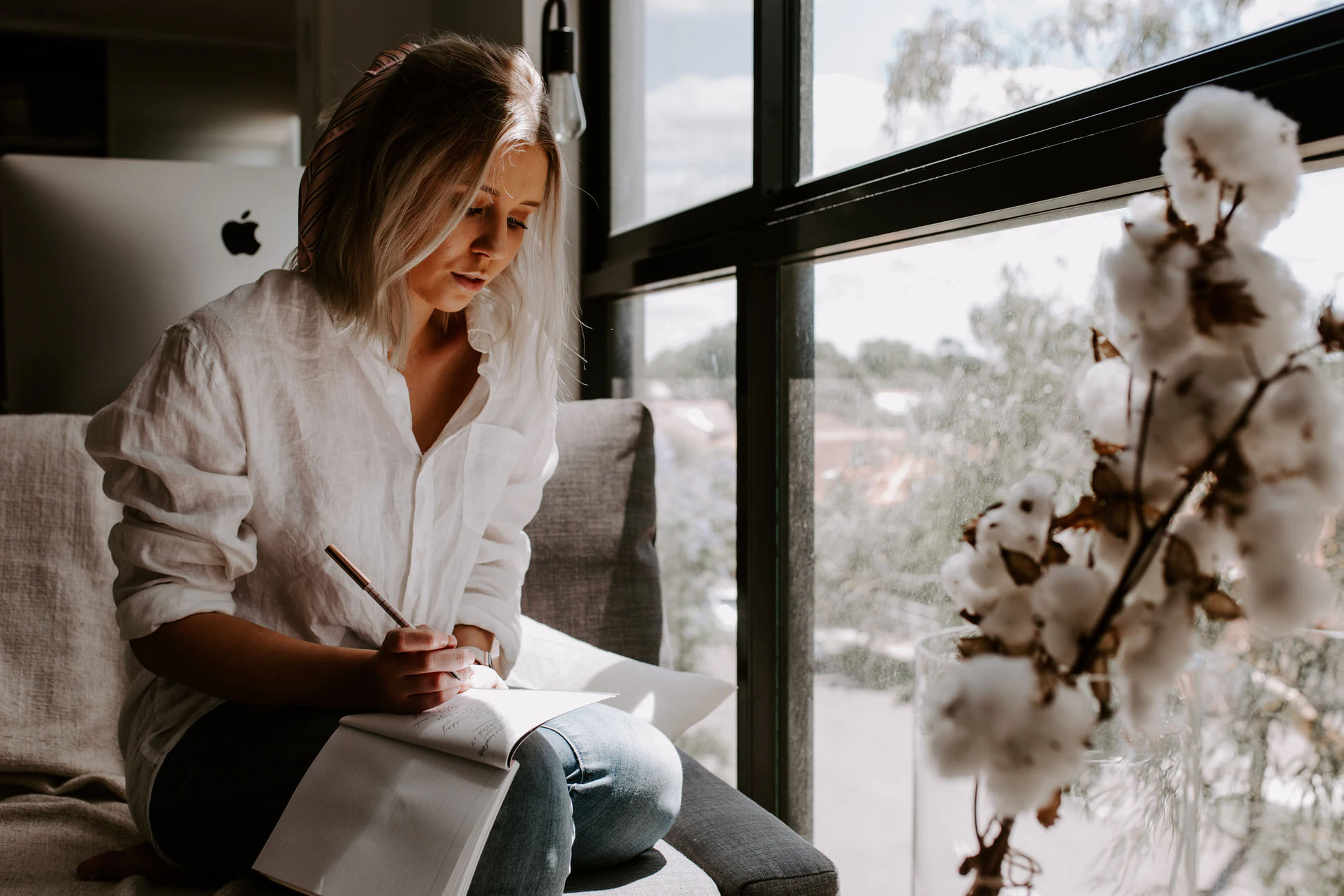 Woman taking notes in front of a window