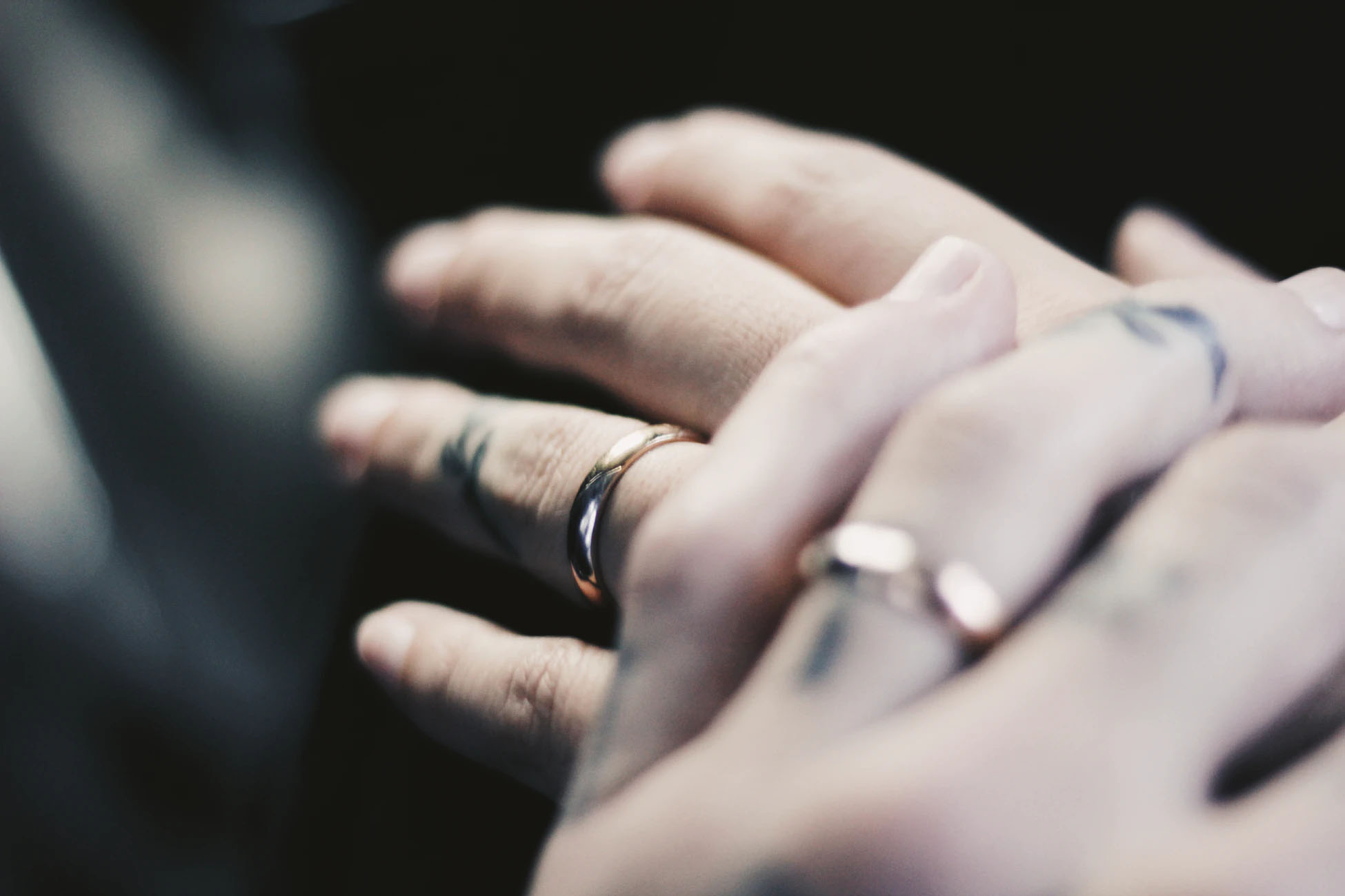 Couple with wedding rings touching hands