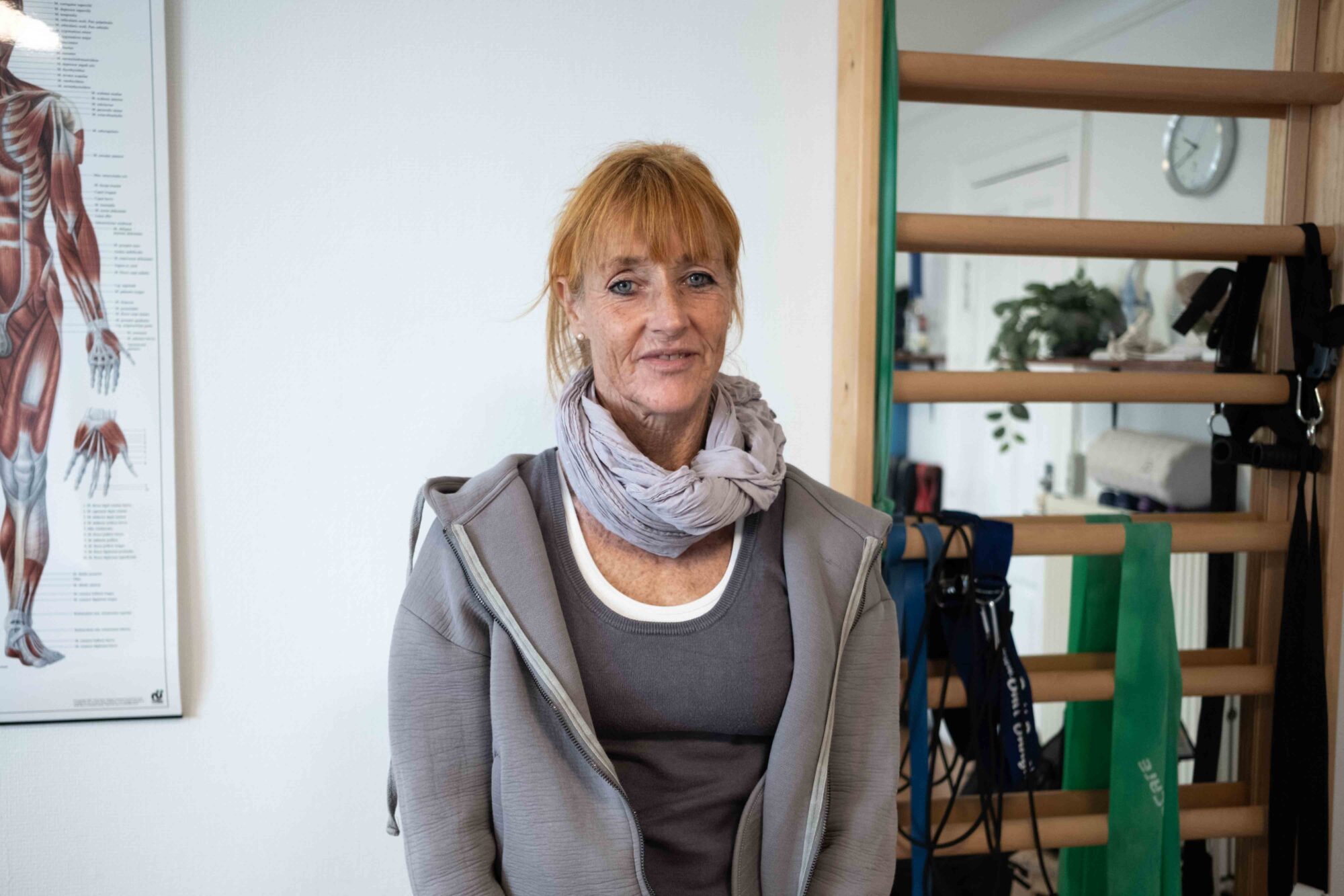 Gitte Vestergaard, en kund hos EasyPractice, står upp och ler mot kameran. 