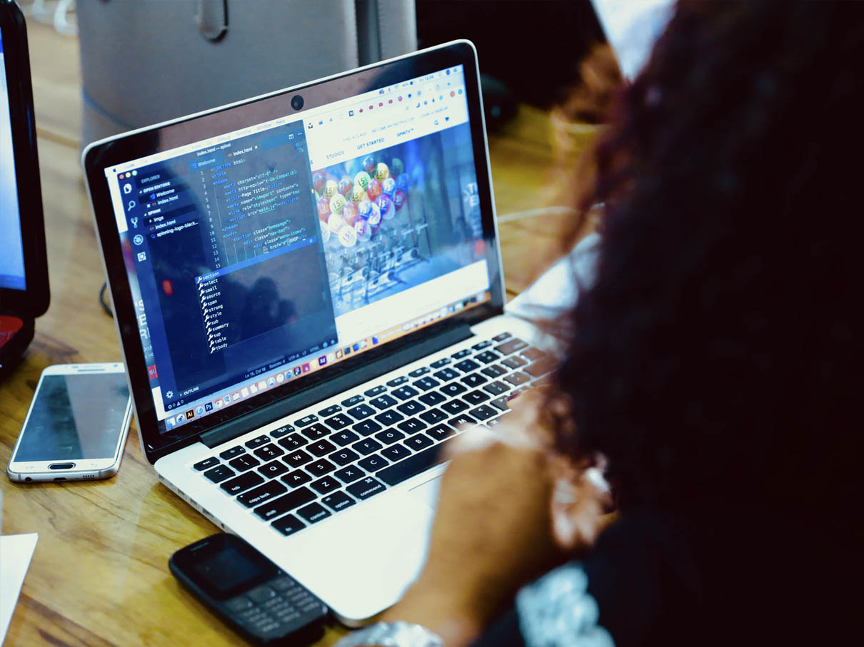 Kvinna framför en laptop som kodar
