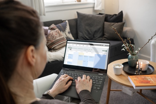 Vår kunde Lise Kramer Schmidt som sitter foran en pc som viser kalenderen hennes i EasyPractice