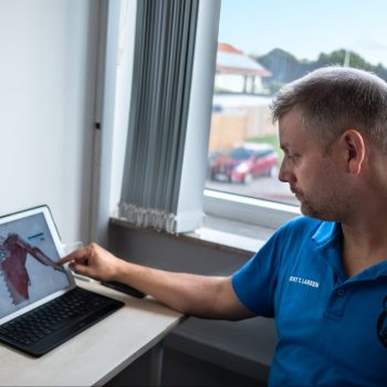 Founder Gert Touvdal Larsen of Sportsmassage4000 sitting in front of his desk and using EasyPractice.