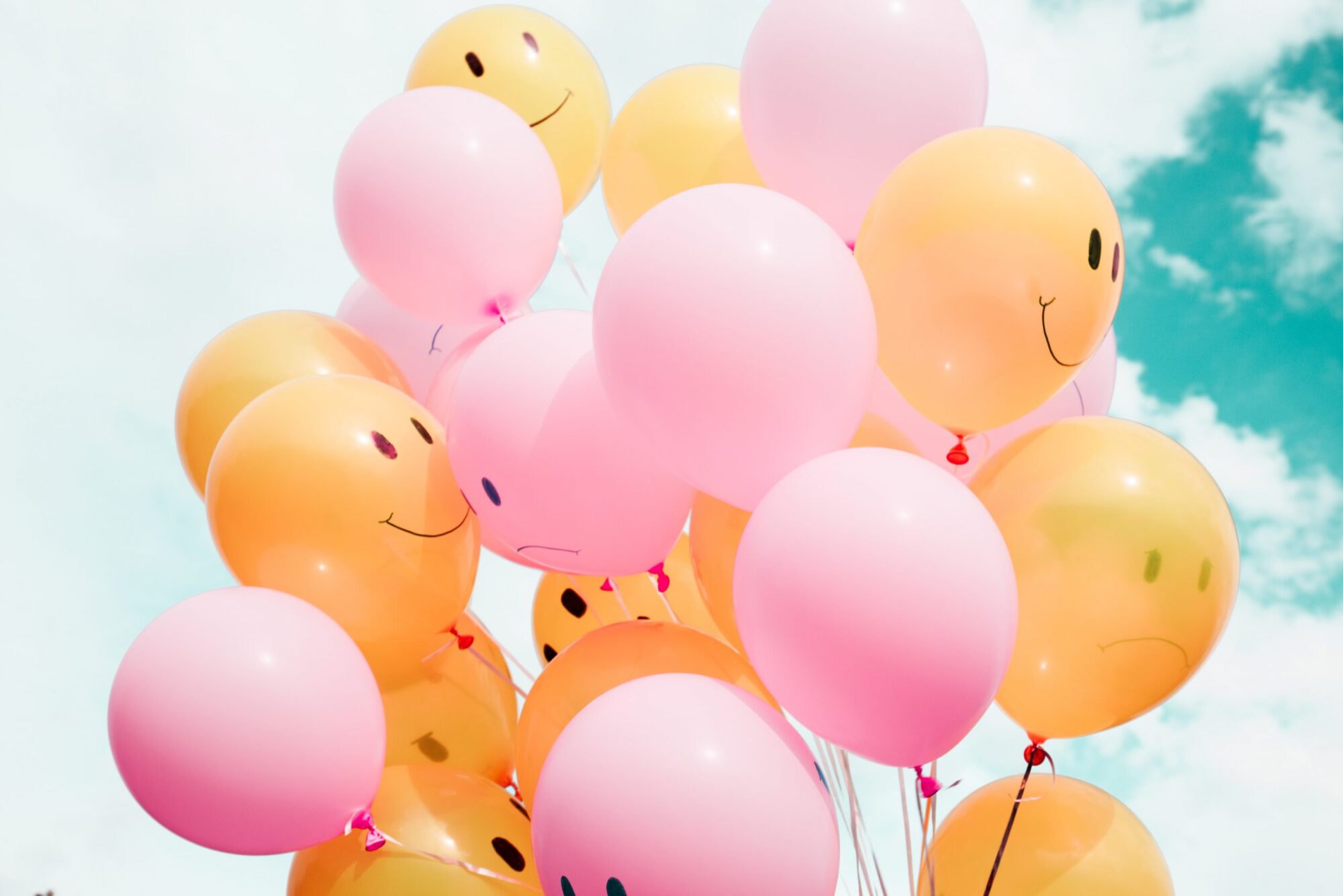 Image of a dozen balloons with smileys on it