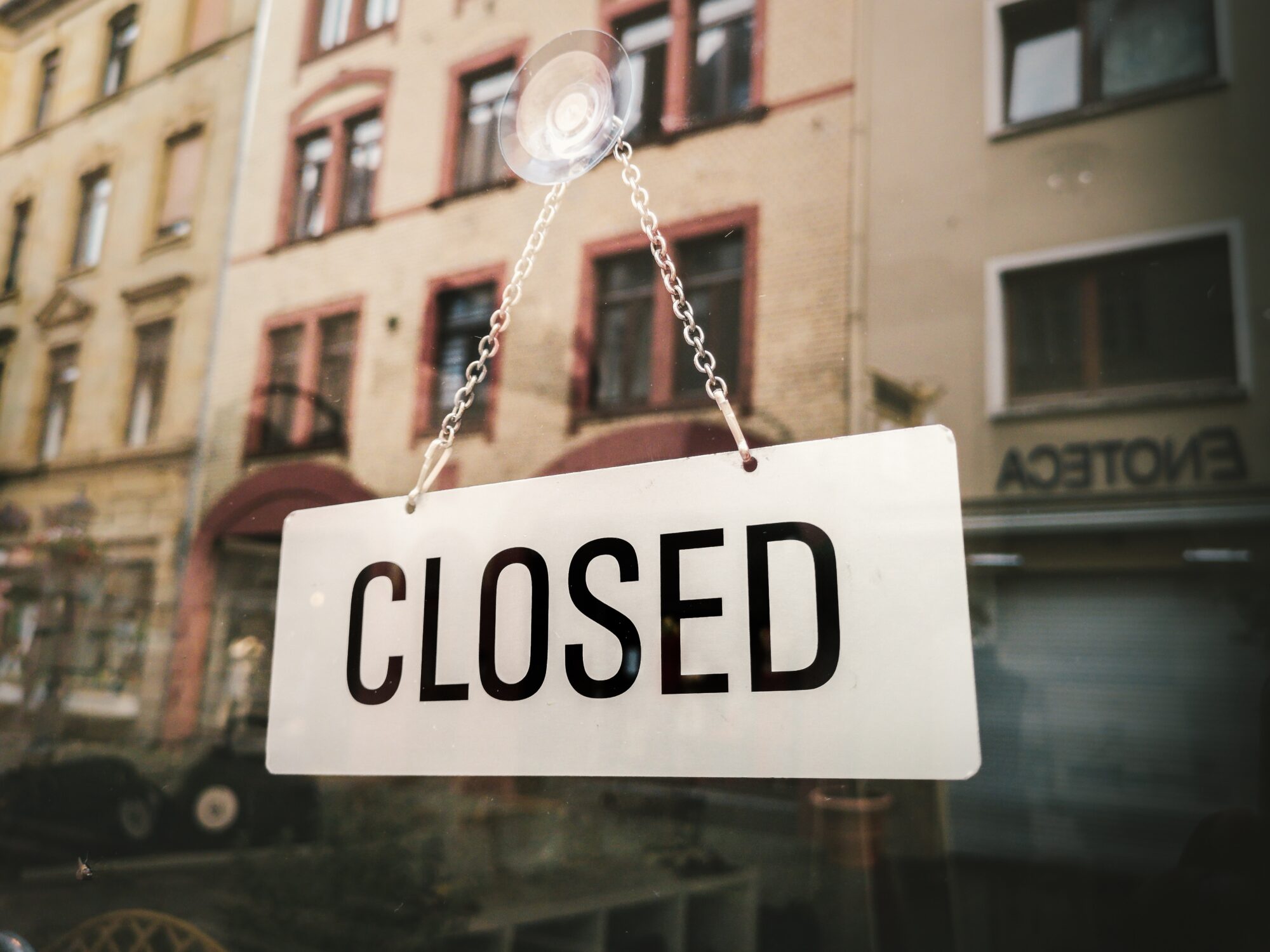 Image of a closed sign hanging at the door of a shop