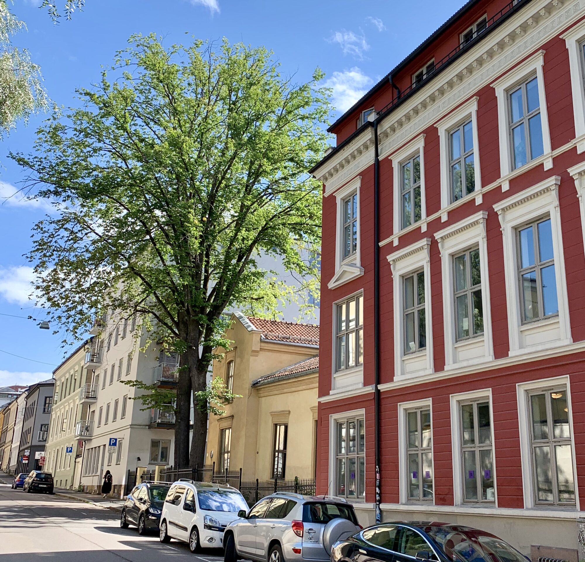 En gate med rød bygning i Oslo by