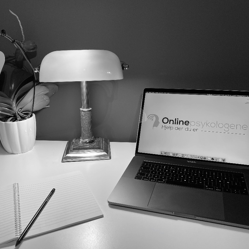 Et kontorbord og pc-skjerm som viser 'Onlinepsykologene'