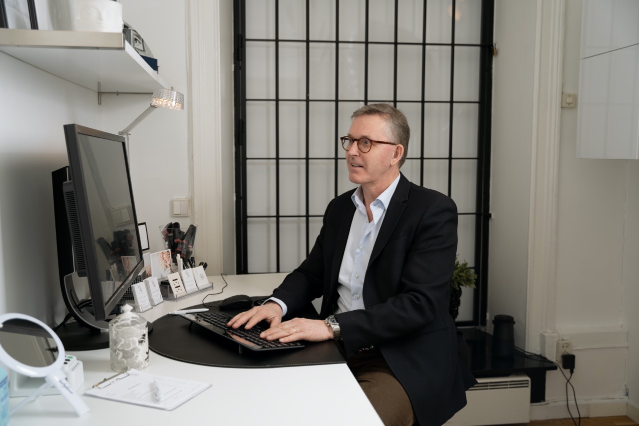 Founders of Humlegårdskliniken sitting in front of a desk and using a PC.