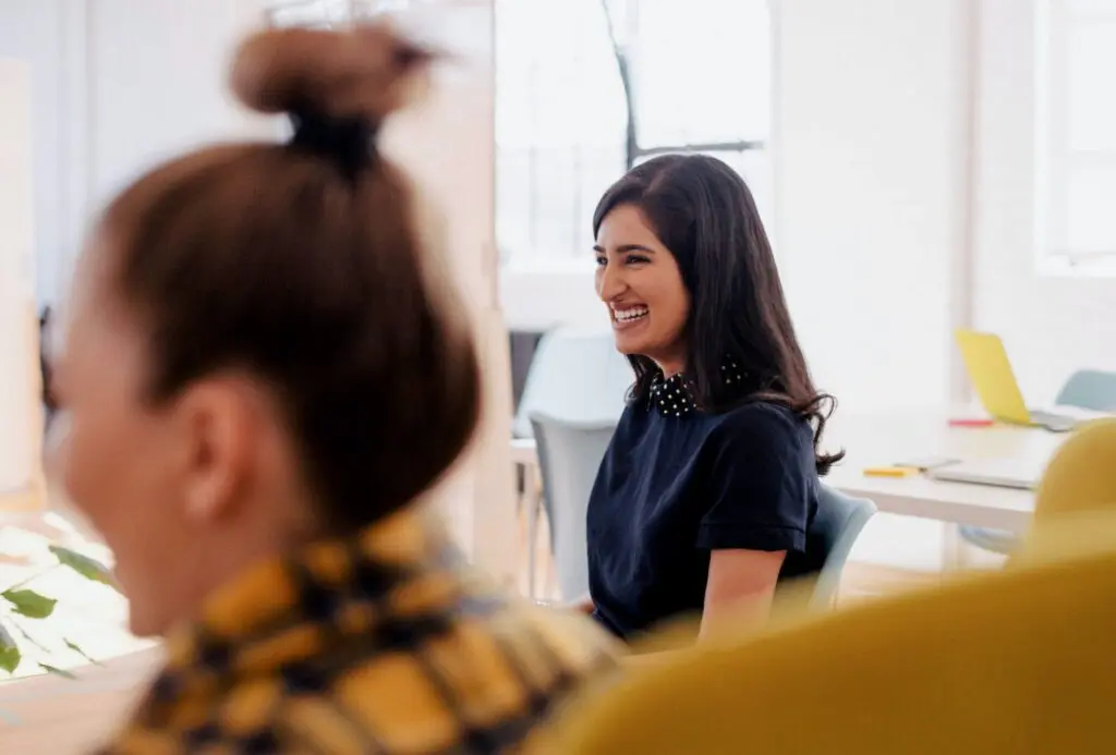 Two laughing woman in a office 