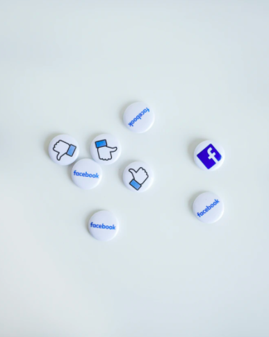 Små knappar på ett vitt bord med Facebook logga