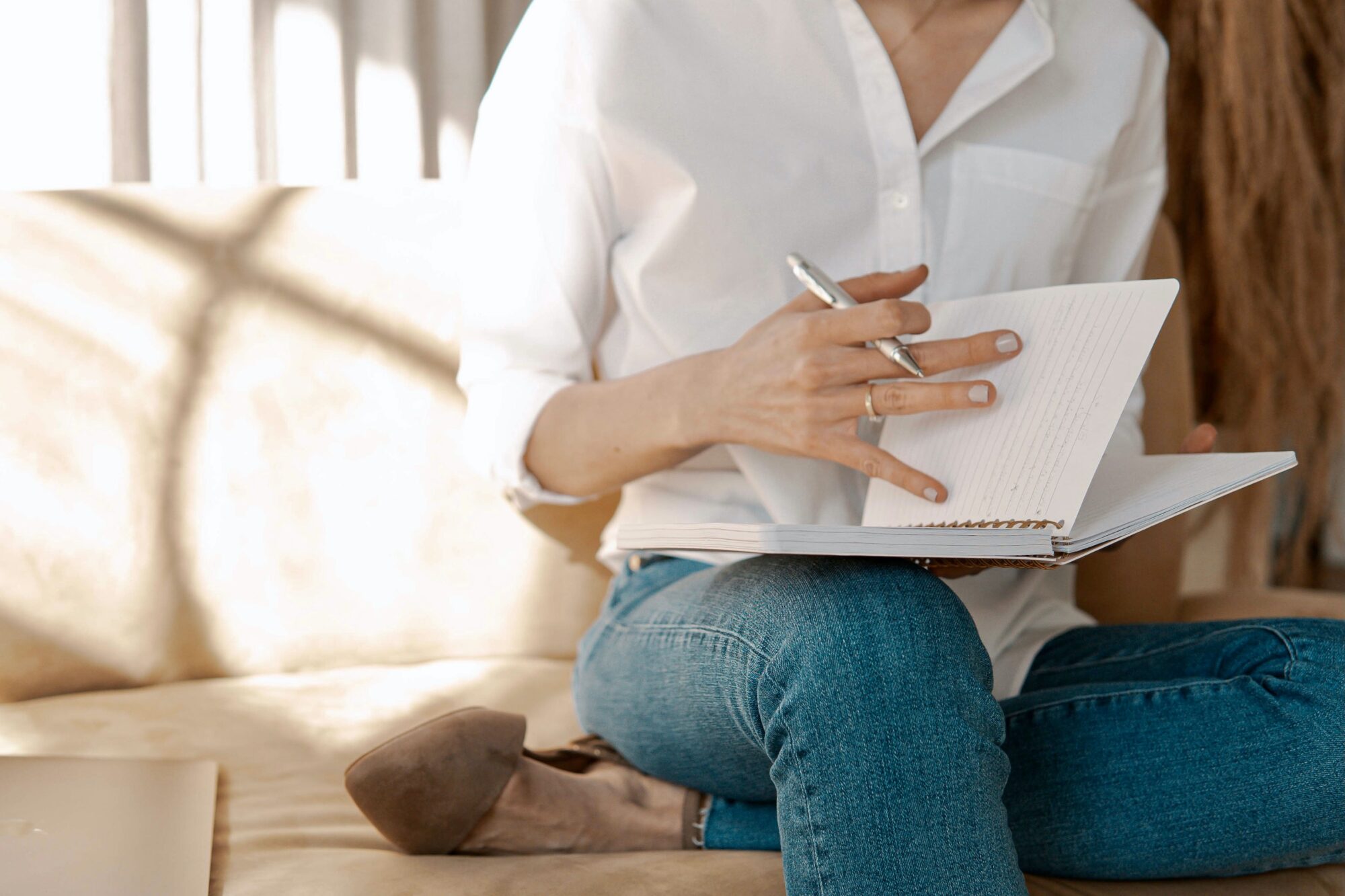 Woman sitting on a sofa and scrolling through her notebook