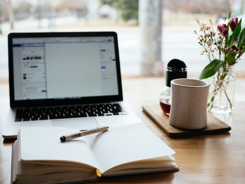 A laptop and notepad on the desk.