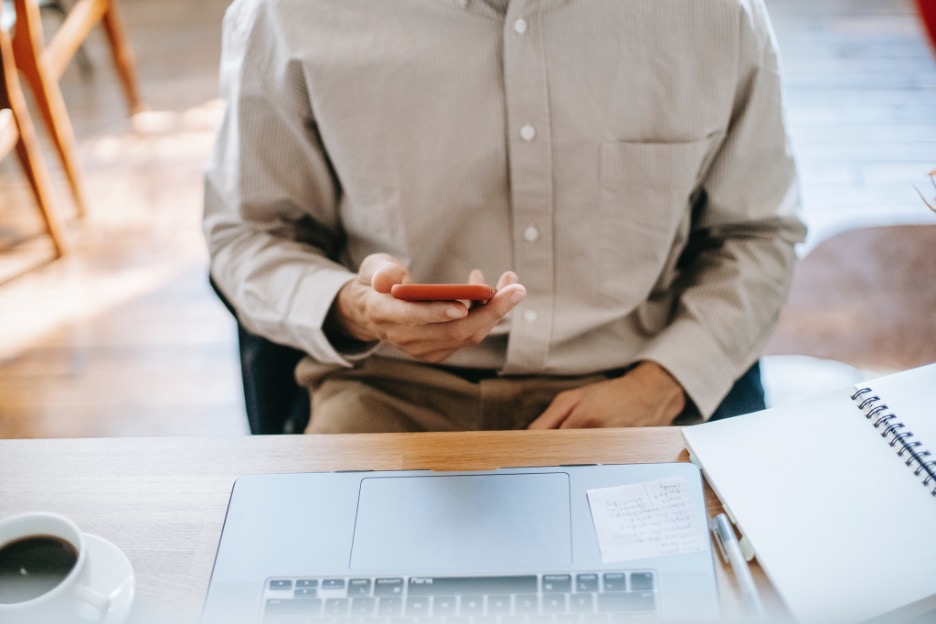 Man siting at a desk and checking his smartphone