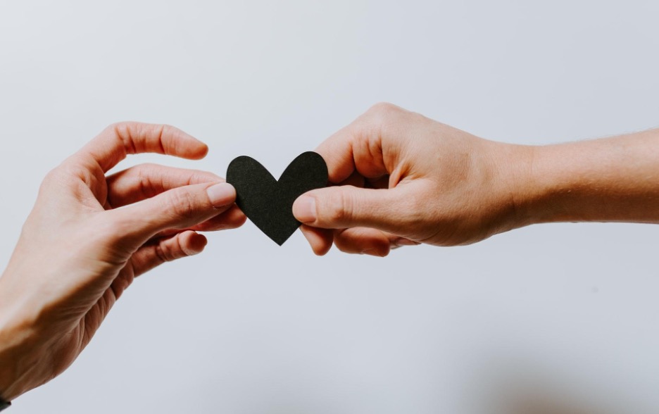 Two hands holding a paper heart