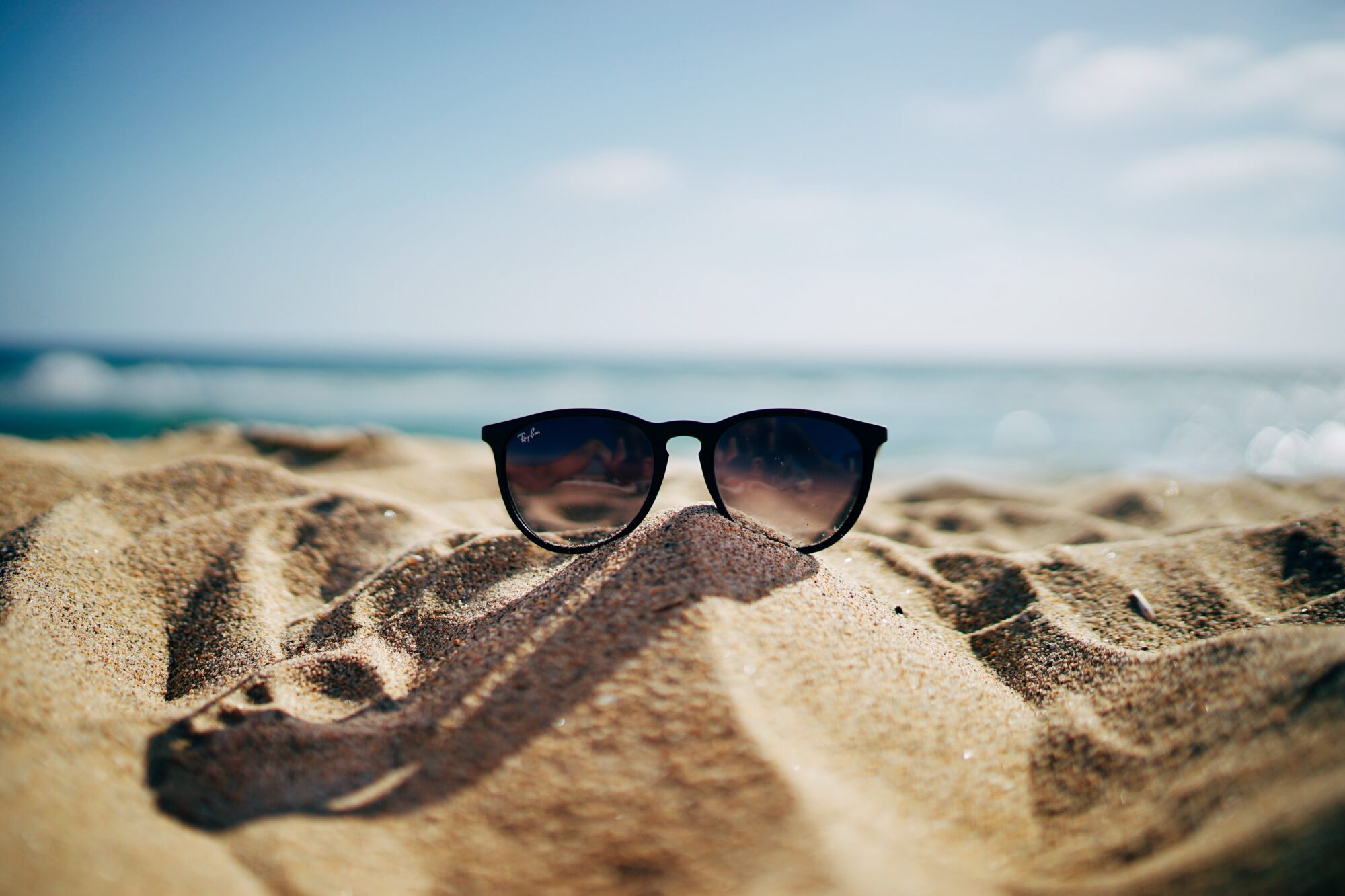 Solbriller på en sandstrand